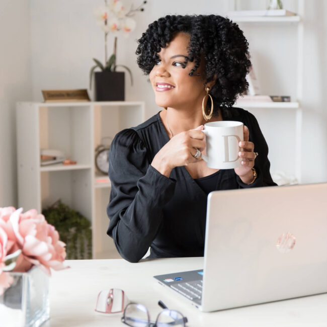 Danielle McGinnis, former Virtual Assistant, sitting at laptop.