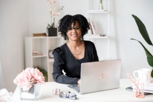 Operations Management Company owner, Danielle sitting at desk in a black shirt. Eliminating a business bottleneck.