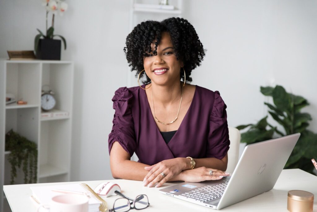 Business Systems Consultant working on client retention on laptop.