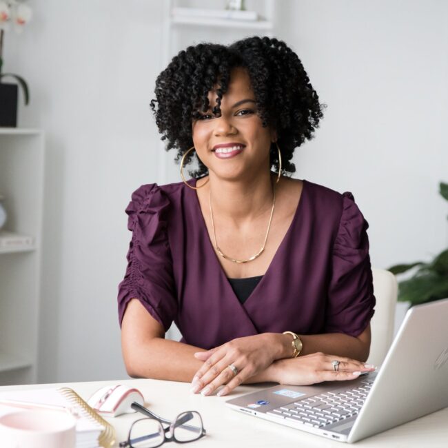 Business Systems Consultant working on client retention on laptop.